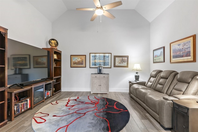 living room featuring ceiling fan, light hardwood / wood-style floors, and lofted ceiling