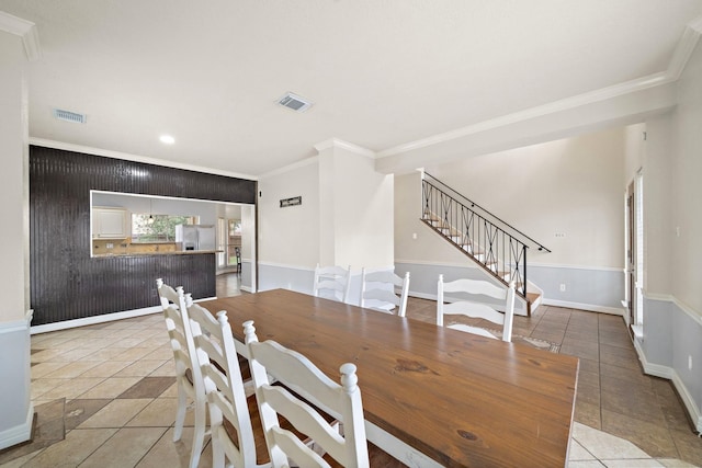 dining room with crown molding and light tile patterned flooring