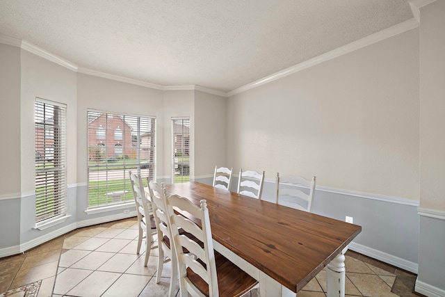 tiled dining room featuring a textured ceiling and crown molding