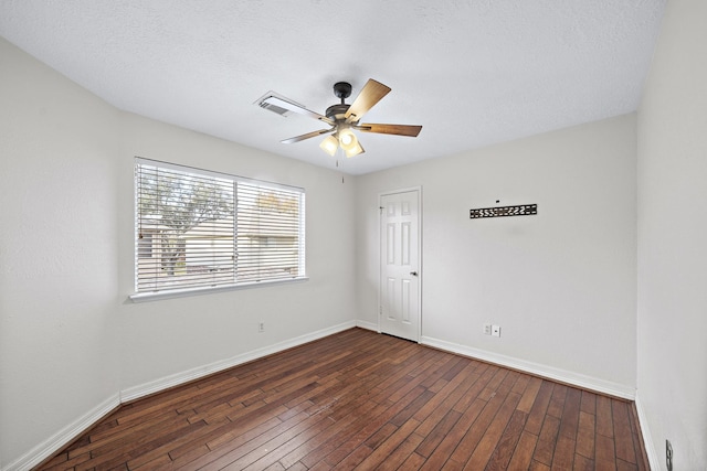 empty room with ceiling fan, dark hardwood / wood-style flooring, and a textured ceiling