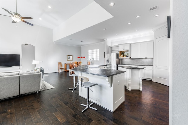 kitchen featuring a breakfast bar area, stainless steel fridge with ice dispenser, a center island, and dark hardwood / wood-style floors