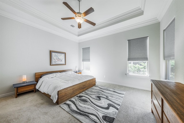 bedroom with ceiling fan, light colored carpet, crown molding, and a tray ceiling