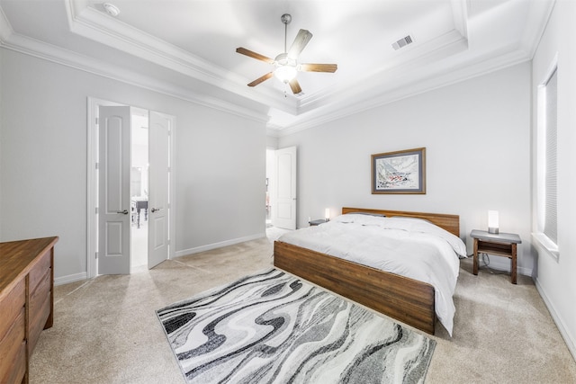 carpeted bedroom with a tray ceiling, ceiling fan, and crown molding