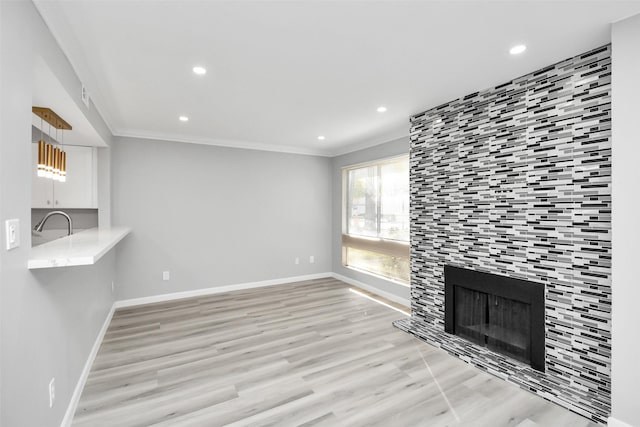 unfurnished living room with a tile fireplace, light hardwood / wood-style flooring, and crown molding