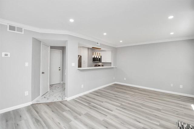 unfurnished living room featuring ornamental molding and light hardwood / wood-style flooring