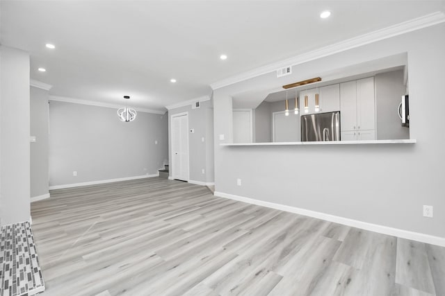 unfurnished living room featuring light wood-type flooring and crown molding