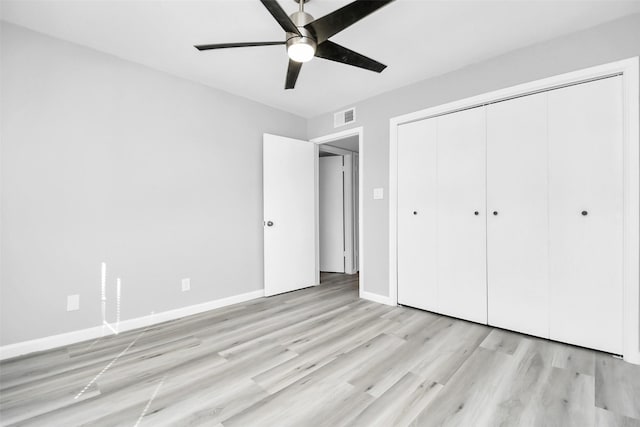 unfurnished bedroom featuring ceiling fan, a closet, and light hardwood / wood-style flooring