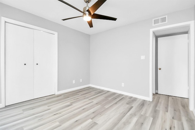 unfurnished bedroom featuring ceiling fan, light hardwood / wood-style floors, and a closet