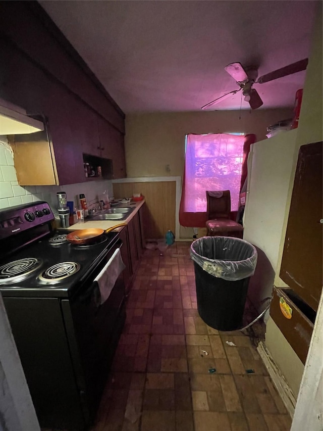 kitchen featuring decorative backsplash, black electric range oven, sink, and ceiling fan