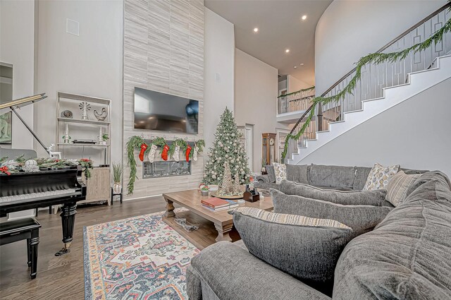 living room with a towering ceiling and hardwood / wood-style flooring