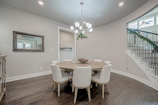 dining space featuring ceiling fan with notable chandelier and dark wood-type flooring