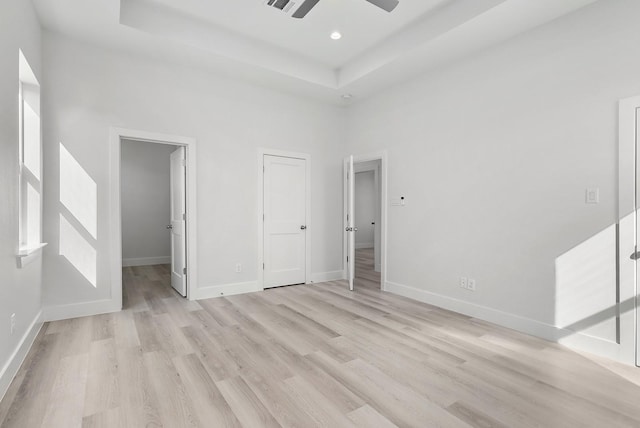 unfurnished bedroom featuring a high ceiling, light wood-type flooring, and ceiling fan