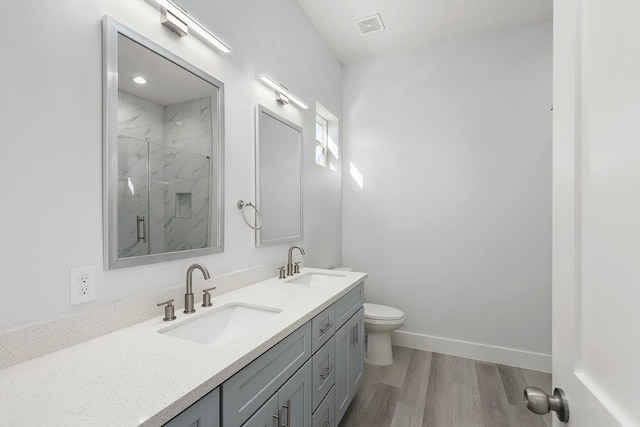 bathroom featuring hardwood / wood-style floors, vanity, an enclosed shower, and toilet