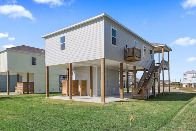 rear view of property featuring a lawn, a balcony, and a patio