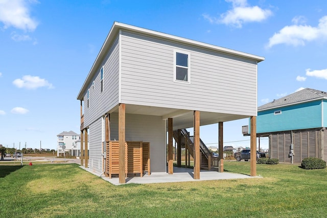 back of house with a patio and a lawn