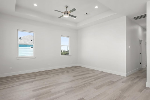 22803 Miramar Dr, Galveston, TX 77554 - spare room featuring a tray ceiling, plenty of natural light, light wood-type flooring, ceiling fan, and recessed lighting
