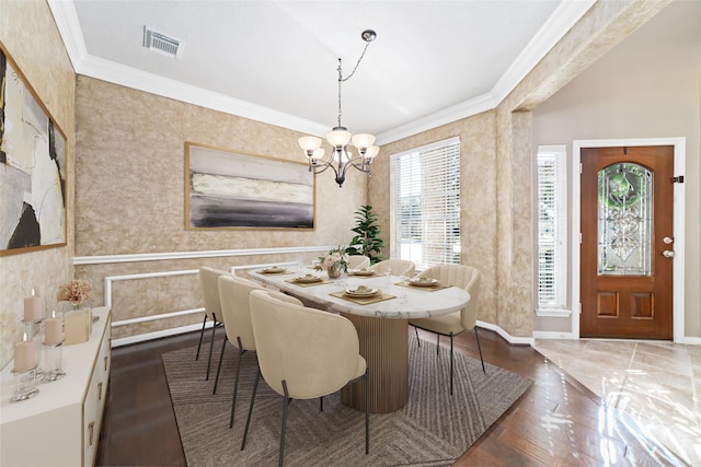 dining space featuring ornamental molding and a chandelier