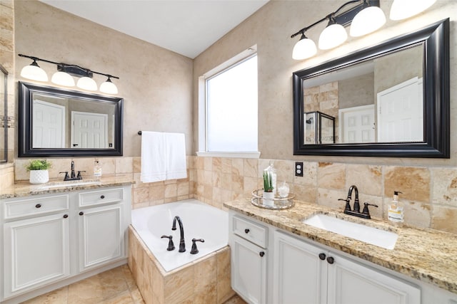 bathroom featuring vanity and tiled tub