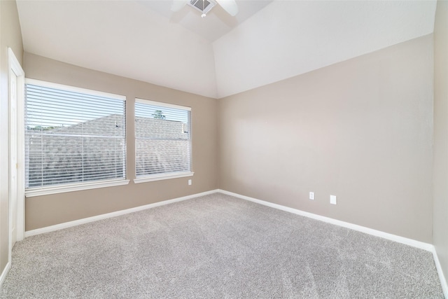 carpeted empty room featuring plenty of natural light and vaulted ceiling