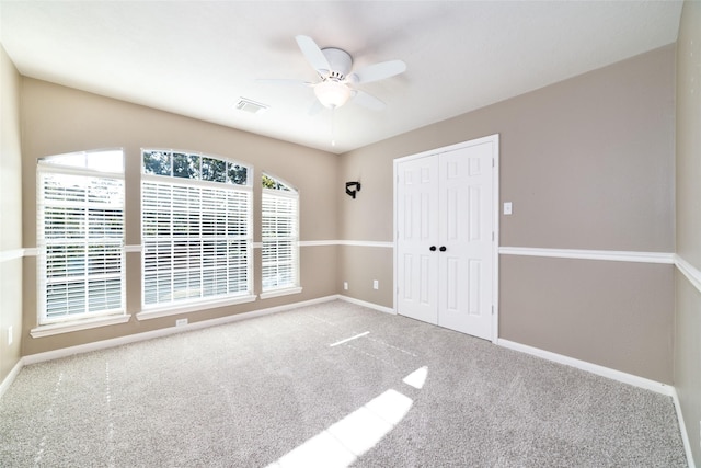 carpeted spare room featuring ceiling fan