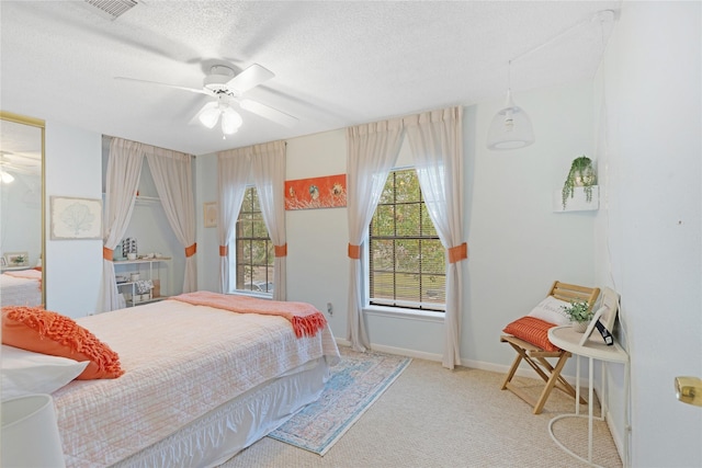 bedroom with light colored carpet, a textured ceiling, and ceiling fan