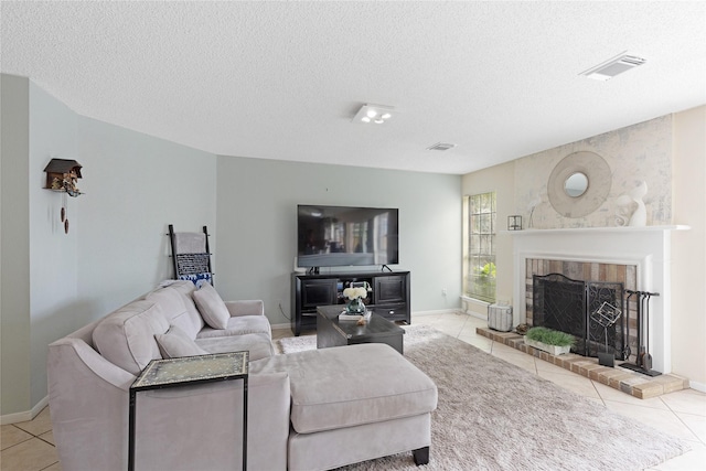 tiled living room featuring a brick fireplace and a textured ceiling