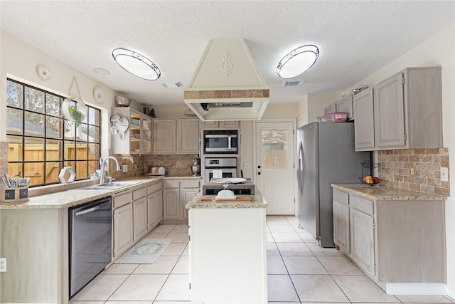 kitchen featuring a kitchen island, appliances with stainless steel finishes, sink, backsplash, and light tile patterned floors