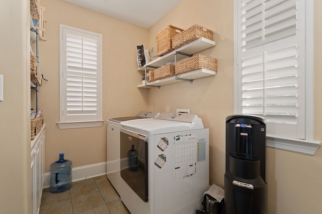 washroom featuring washer and dryer, light tile patterned flooring, and a wealth of natural light