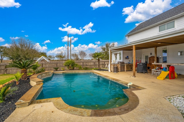 view of pool with grilling area, a patio area, and exterior kitchen