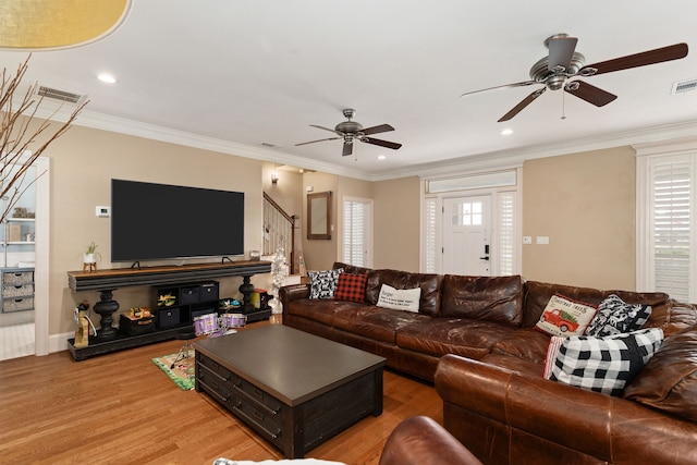 living room featuring crown molding, plenty of natural light, and hardwood / wood-style flooring