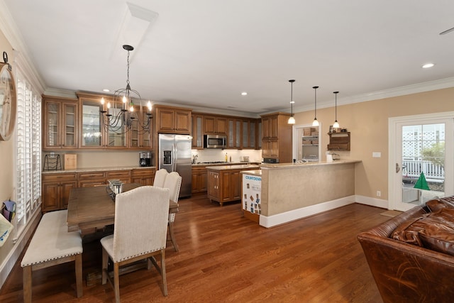 dining area with dark hardwood / wood-style flooring, crown molding, and an inviting chandelier