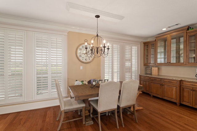 dining room with an inviting chandelier, dark wood-type flooring, and crown molding