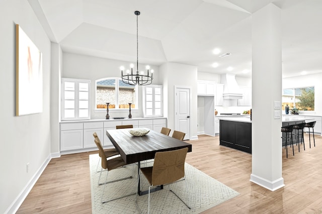 dining space with an inviting chandelier, a wealth of natural light, and light hardwood / wood-style flooring