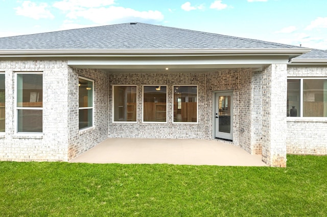 rear view of property with a yard and a patio