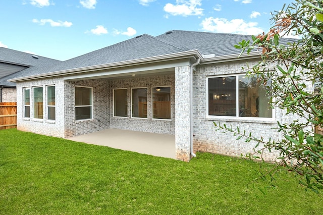 rear view of house with a lawn and a patio