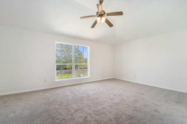 carpeted spare room featuring ceiling fan