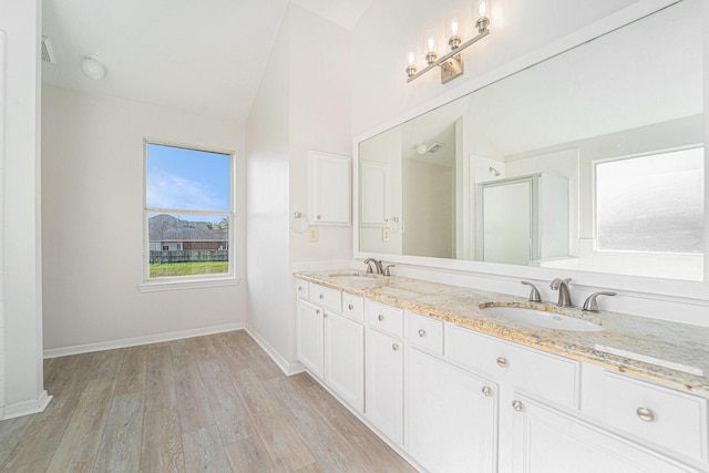 bathroom featuring a shower with shower door, vanity, wood-type flooring, and lofted ceiling