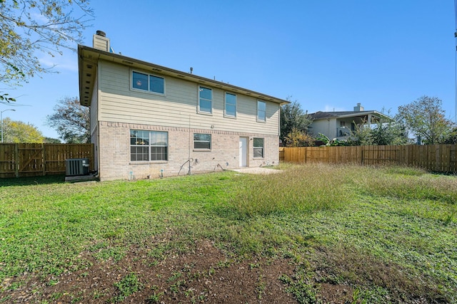 back of house featuring a lawn and central AC unit