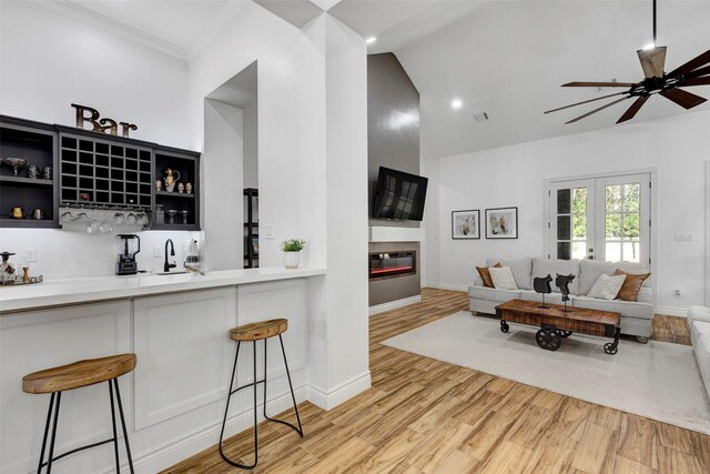 interior space featuring french doors, ceiling fan, sink, hardwood / wood-style floors, and a breakfast bar area