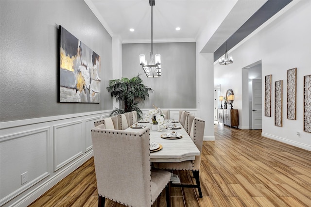 dining space featuring a chandelier, crown molding, and light hardwood / wood-style flooring