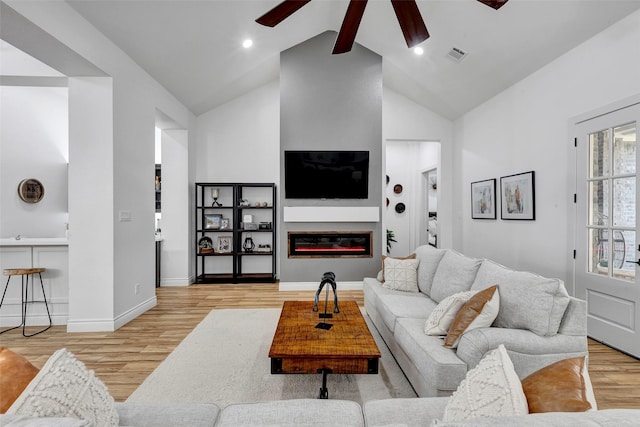 living room featuring beam ceiling, ceiling fan, high vaulted ceiling, and light hardwood / wood-style floors