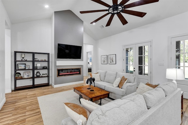 living room with ceiling fan, high vaulted ceiling, and light hardwood / wood-style floors