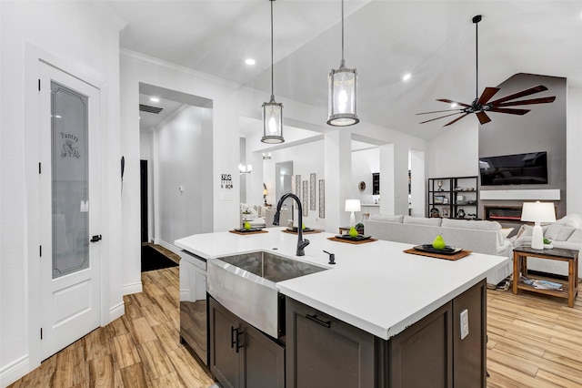 kitchen with light hardwood / wood-style floors, lofted ceiling, sink, and hanging light fixtures