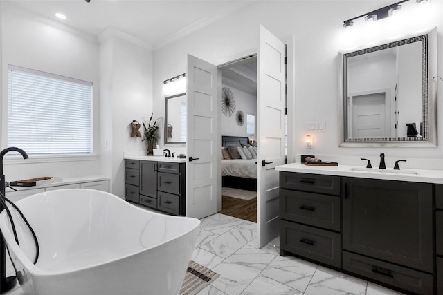 bathroom with crown molding, vanity, and a bath