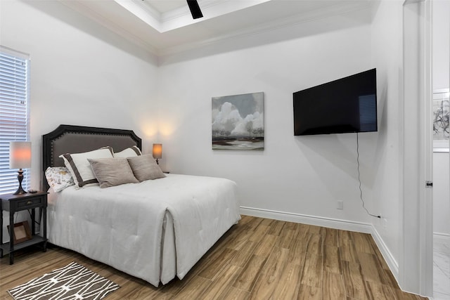 bedroom featuring multiple windows, ceiling fan, hardwood / wood-style floors, and ornamental molding