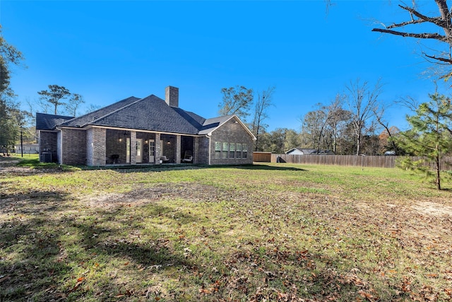 back of house featuring a lawn