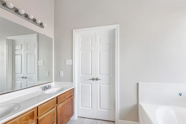 bathroom featuring tile patterned flooring, vanity, and a tub to relax in