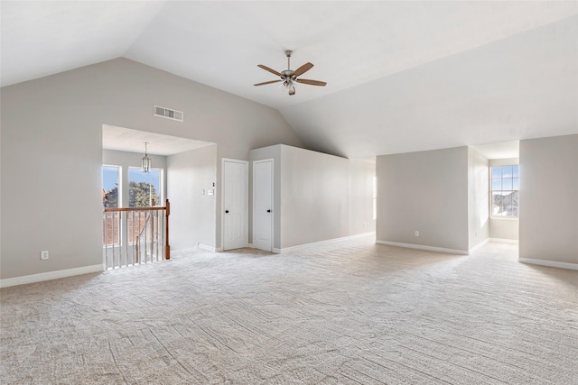 carpeted spare room with ceiling fan and vaulted ceiling