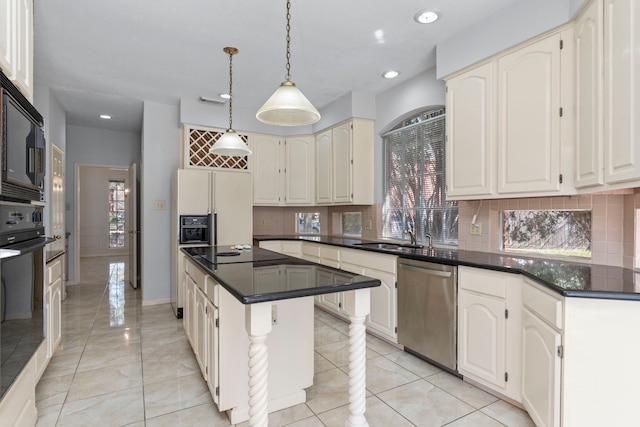 kitchen featuring dark countertops, a center island, hanging light fixtures, black appliances, and a sink