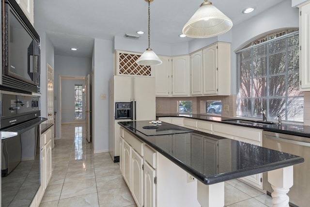 kitchen with a center island, visible vents, hanging light fixtures, a sink, and black appliances